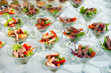 wine glasses with salad and meat snack at reception. catering snack service