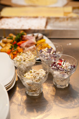 Serving for a banquet table with glasses and white plates and salads, vegetables