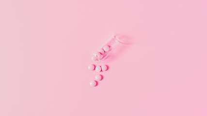 top view of pink medicines spilled from bottle on pink tabletop