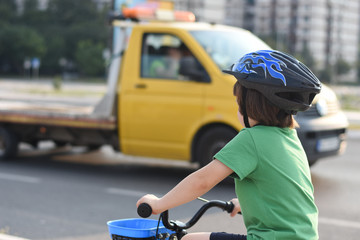 Five years old boy rides a bicycle in the city. Child riding bicycle outdoor on sunny day