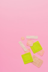 top view of various adhesive bandages on pink tabletop