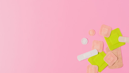 top view of various adhesive bandages on pink surface