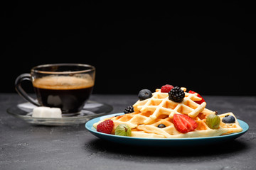 Photo of cup of coffee with sugar with Viennese waffles with strawberries, raspberries