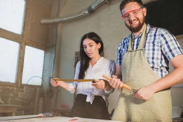 A young man and a woman work in an architectural workshop.