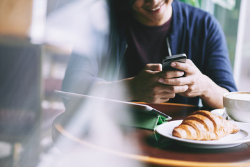 Man texting and eating breakfast