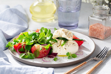 Salad with burrata cheese, tomatoes and corn salad.  