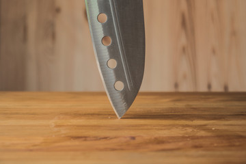 Knife on a wooden board. Stainless steel blade.