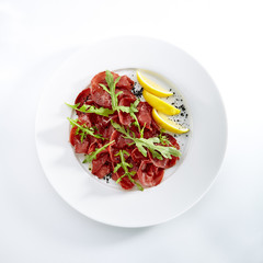 Dried Italian Beef Bresaola with Lemon and Greens Isolated