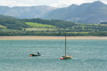 Fototapeta na wymiar Boats in the Menai Strait and Snowdonia in the background on sunny day in summer - 3