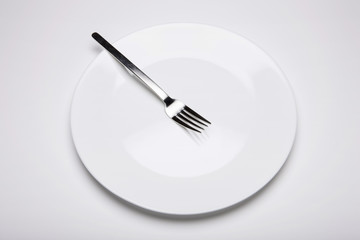 white empty dish with fork on the white background.