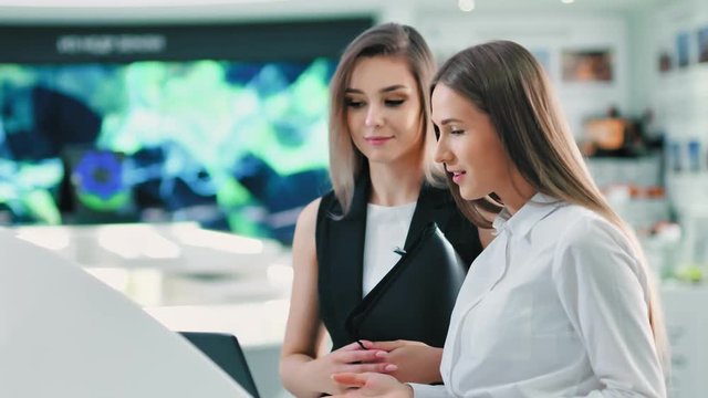 Portrait of two attractive European businesswoman at hitech futuristic exhibition