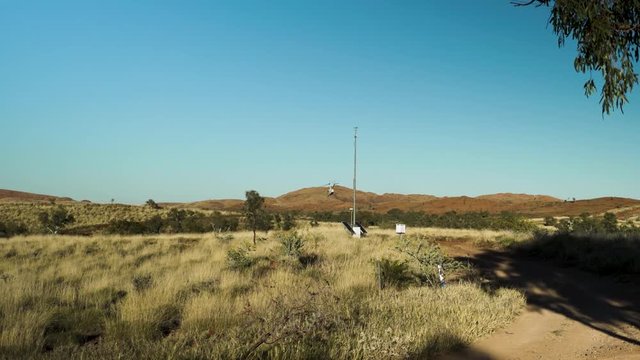 Helicopter taking off from a clearing on a sunny afternoon in the Pilbara of Western Australia