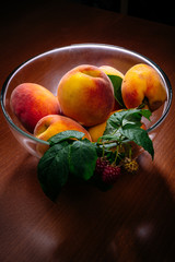 Peaches and raspberries in a glass plate