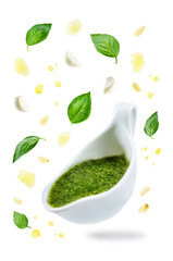Pesto sauce with flying ingredients to prepare it