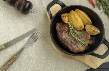 A roasted piece of meat on a cast iron frying pan.