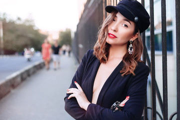 Outdoor portrait of a young beautiful fashionable woman wearing stylish accessories.Wearing hat and jacket. Female fashion, beauty and advertisement concept. Close up. Copy space for text.