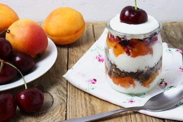 Glass dessert made of yogurt, granola, apricots and cherries