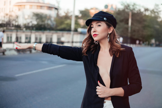 Graceful brunette woman in vintage coat walking down the street with phone in hand. Outdoor portrait of smiling refined girl in hat.gesture, transportation, travel, tourism and people concept.