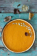Traditional American pumpkin pie for Thanksgiving Day or Halloween on a wooden background. Rustic style.
