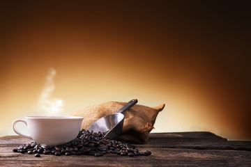 Cup of coffee  and coffee beans on old wooden background