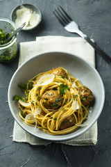 Pasta with meatballs, parmesan cheese and pesto