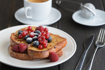 Good breakfast background.  French toasts with berries and icing sugar  cup of coffee on wooden table.
