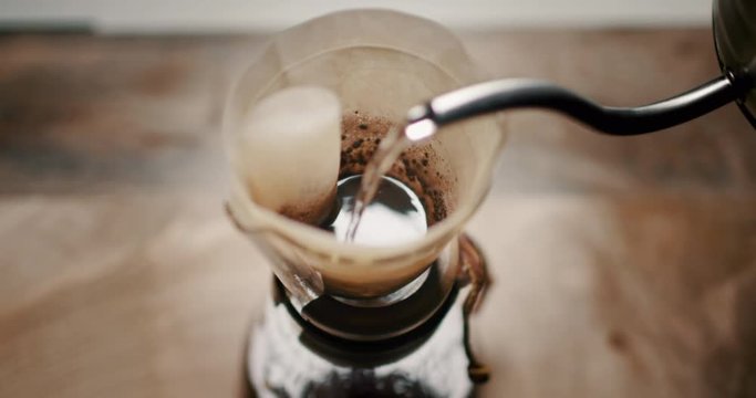 Making feashly brewed chemex filter coffee on black background