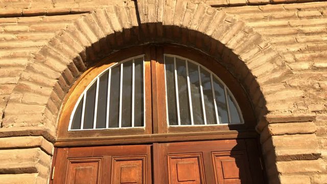 old wooden door, brick wall and arch, construction of the old Asylum of the Little Sisters of the Poor located in Santiago de Chile. Convent of Nuns built in 1898.