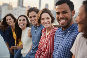 Friends Gathered On Rooftop Terrace For Party With City Skyline In Background