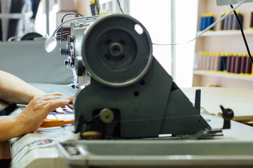 Woman hands works with sewing machine
