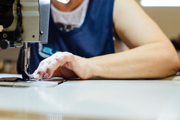 Woman sews leather piece