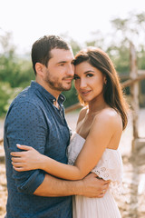 couple hugging outdoors and looking at camera