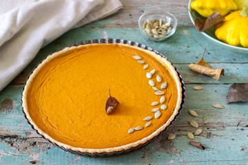 Traditional American pumpkin pie for Thanksgiving Day or Halloween on a wooden background. Rustic style.