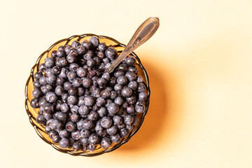 blueberries in a glass plate on an orange background