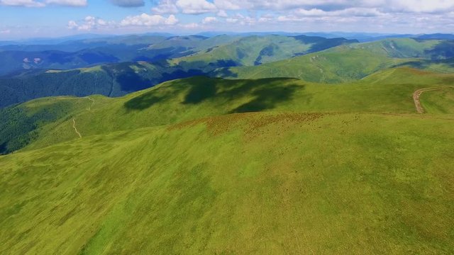 Aerial shot of long ridges with cloud tints in the Carpathians in summer