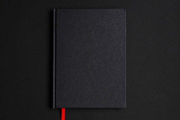 Black notepad on a black background. Black branding mockup
