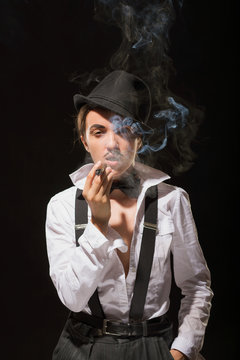 The smoking woman becomes similar to the man. Against a dark background. (with rigid light and shadows)