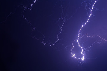 Lightning storm over city in purple light