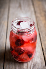 Fototapeta na wymiar Cherry cocktail with ice in glass jar. Selective focus.