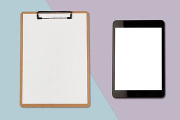 Digital tablet with blank screen and clipboard on pastel color background, flat lay photo