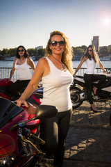weibliche Motorradfahrerinnen am Flussufer einer Gro&szlig;stadt