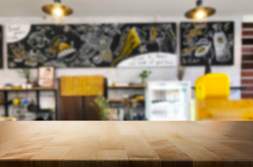 Selected focus empty brown wooden table and Coffee shop or restaurant blur background with bokeh image. for your photomontage or product display
