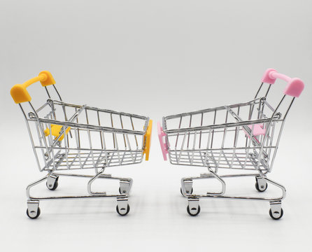 Empty two shopping cart, pink and yellow ,side view, isolated on white background.