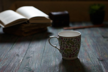 A cup of coffee in the workplace on a wooden table.