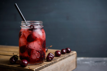 Cherry cocktail with ice in glass jar. Selective focus.
