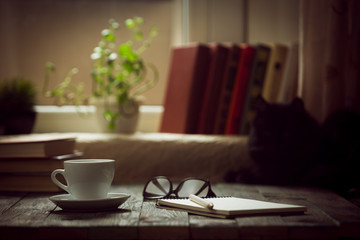 A cup of coffee in the workplace on a wooden table.