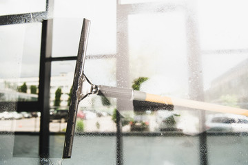 close-up view of cleaning and wiping window with squeegee