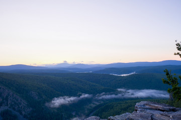 Dawn on top of the mountain. The fog at the bottom