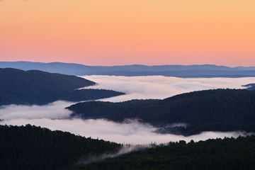 Dawn on top of the mountain. The fog at the bottom