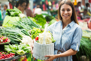 Young woman buying vegetables at the market.